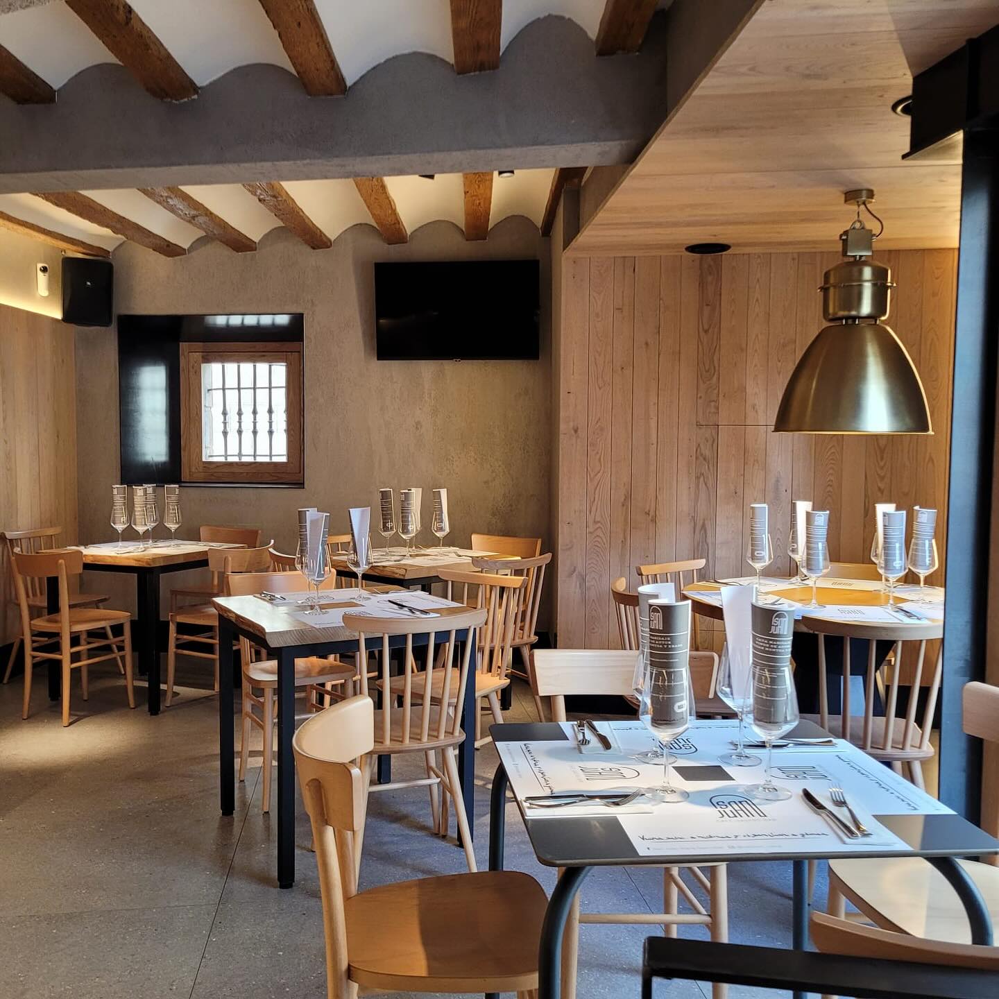 Comedor del Gastrobar San Juan con mesas de madera y vigas vistas